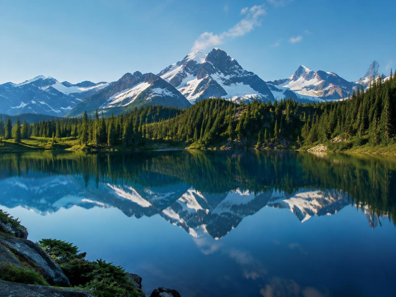 Snow-capped mountains reflected in a still alpine lake